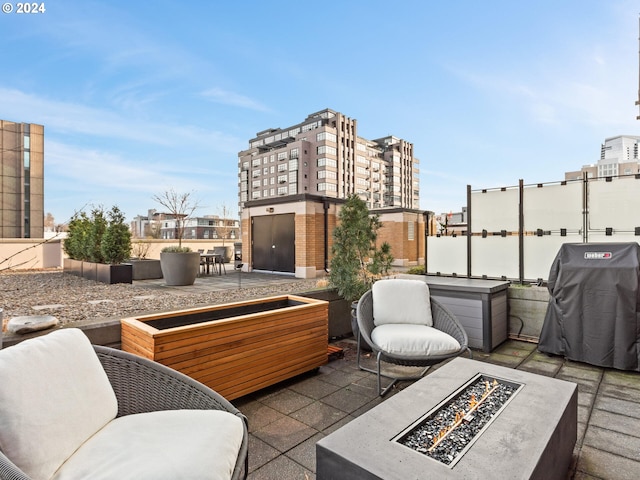 view of patio with a tile fireplace, a fire pit, and a grill