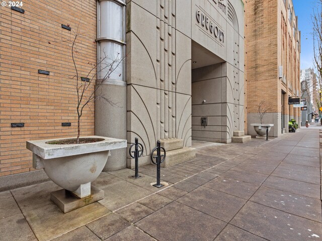 bathroom featuring a towering ceiling, brick wall, and a soaking tub