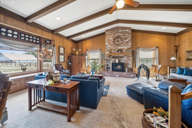 living room with plenty of natural light, a brick fireplace, ceiling fan, and vaulted ceiling with beams