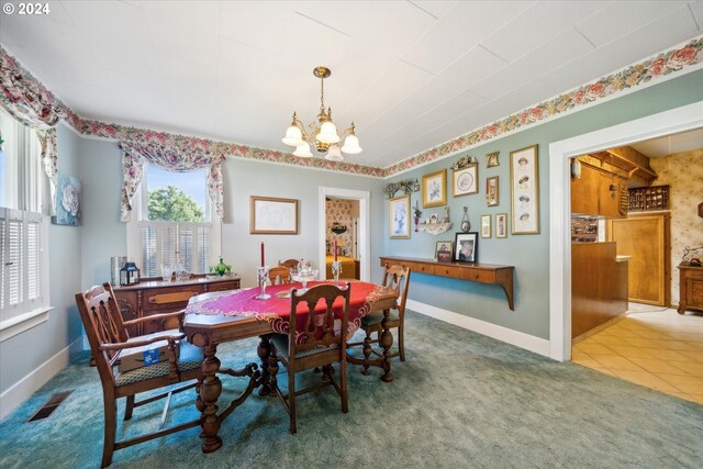 dining space with light colored carpet and a notable chandelier