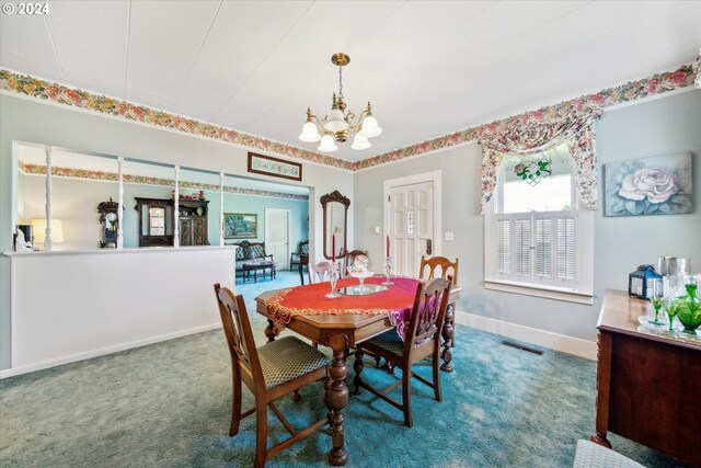 dining room featuring a chandelier and carpet floors