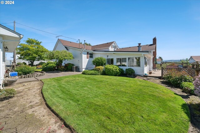 view of front of house with a front yard and cooling unit