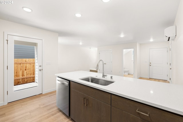 kitchen featuring dishwasher, sink, a wall mounted air conditioner, dark brown cabinets, and light wood-type flooring