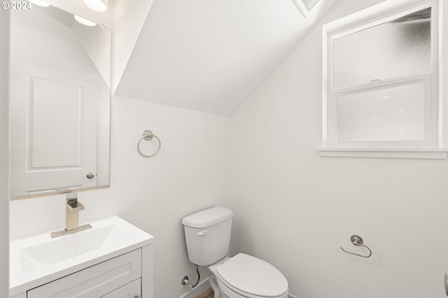 bathroom with vanity, toilet, and lofted ceiling