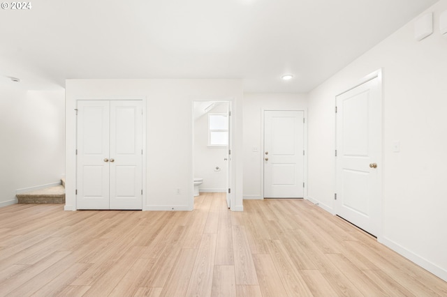 unfurnished bedroom featuring light hardwood / wood-style floors and ensuite bath