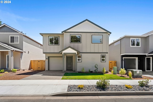 view of front of home with a garage and central air condition unit