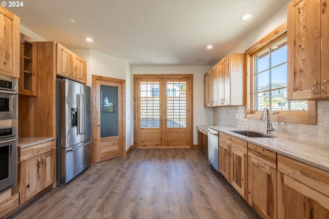 kitchen with backsplash, french doors, sink, dark hardwood / wood-style floors, and appliances with stainless steel finishes