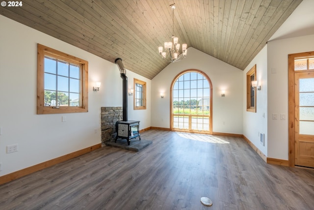 unfurnished living room featuring hardwood / wood-style floors, a wood stove, wood ceiling, and a chandelier