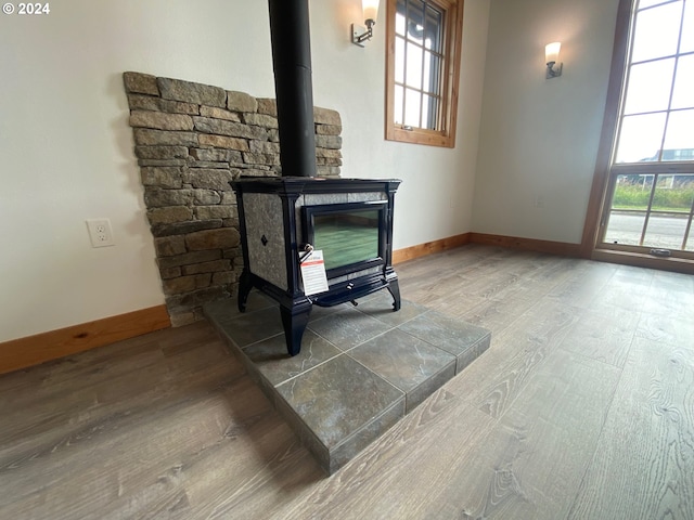 details with a wood stove and wood-type flooring