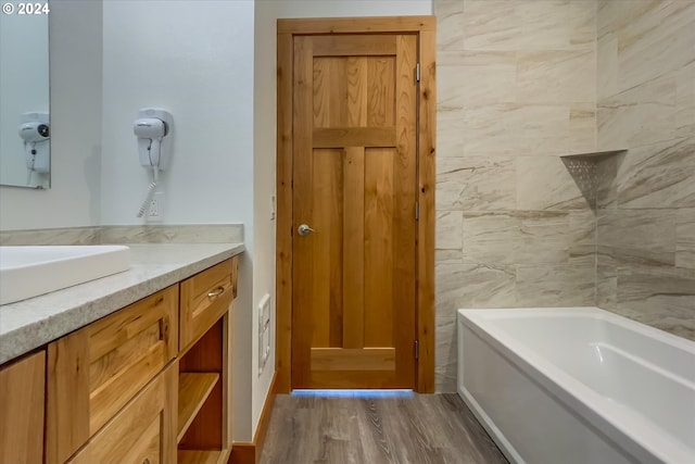 bathroom featuring hardwood / wood-style floors, vanity, and a tub to relax in