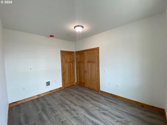 unfurnished bedroom featuring wood-type flooring and a closet