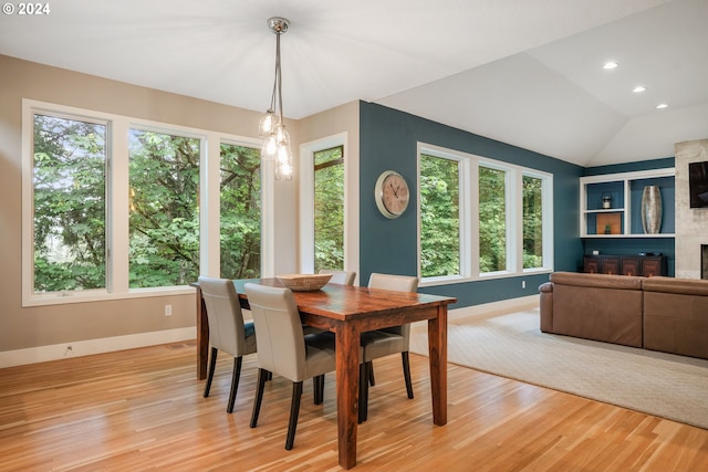 dining area featuring light hardwood / wood-style flooring, a healthy amount of sunlight, and lofted ceiling