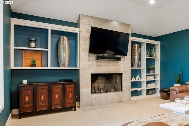 carpeted living room featuring built in shelves and a tiled fireplace