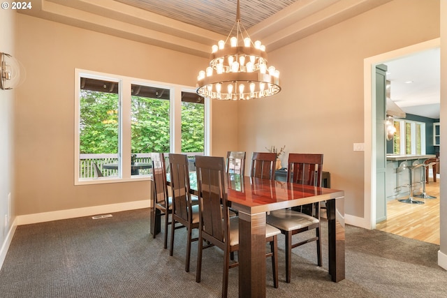 dining space with an inviting chandelier, carpet floors, and a tray ceiling