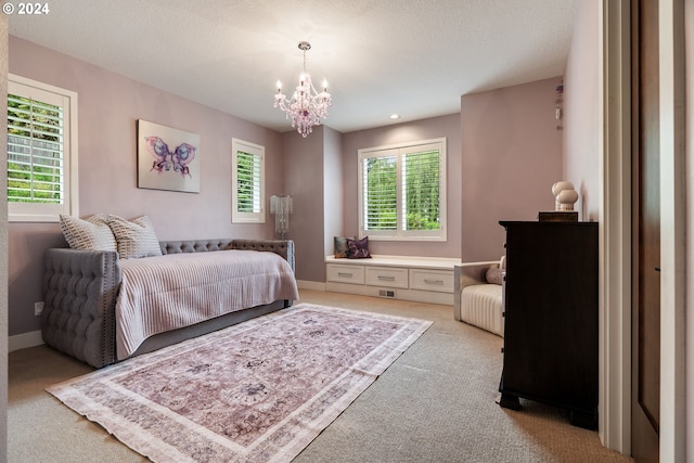 carpeted bedroom featuring a textured ceiling and an inviting chandelier