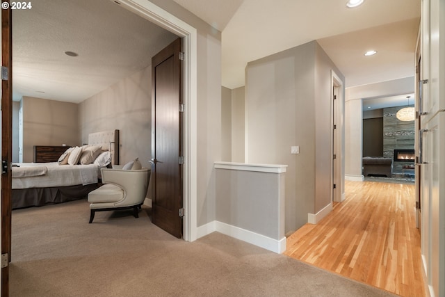 carpeted bedroom with a large fireplace and a textured ceiling