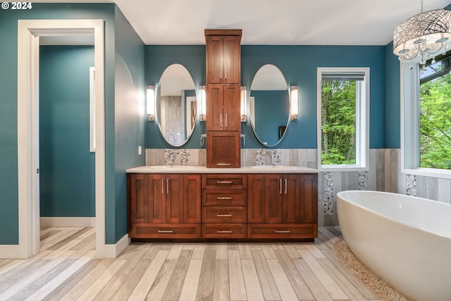 bathroom featuring a bathtub, vanity, an inviting chandelier, and hardwood / wood-style flooring