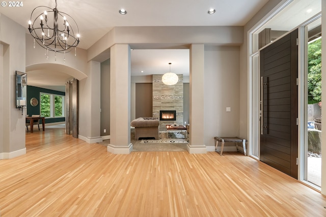 foyer with a tile fireplace, light wood-type flooring, and a wealth of natural light