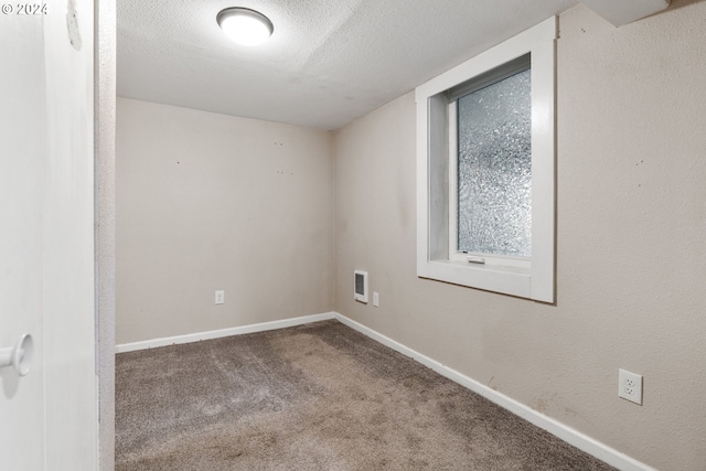 unfurnished room with carpet floors and a textured ceiling