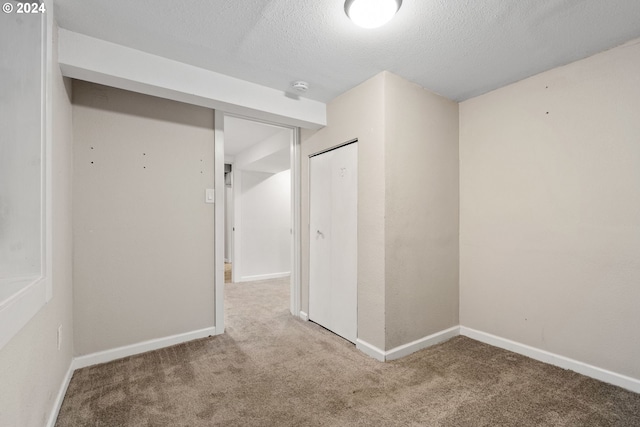 interior space with a textured ceiling and carpet flooring