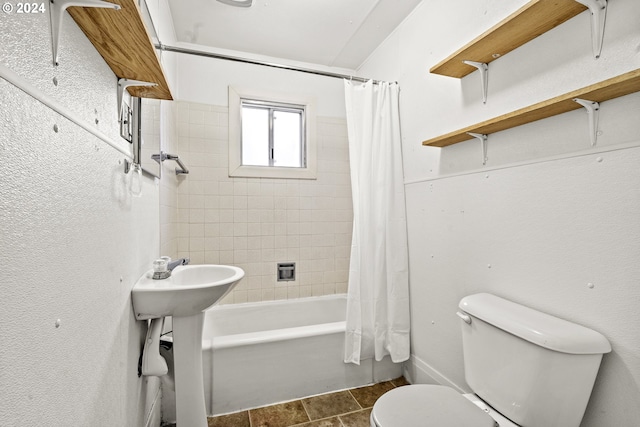 bathroom featuring tile patterned floors, shower / bathtub combination with curtain, and toilet