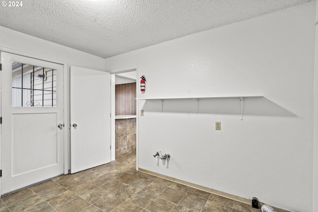 clothes washing area featuring a textured ceiling