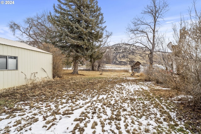 yard layered in snow with a mountain view