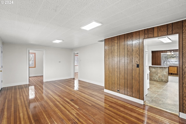 spare room featuring hardwood / wood-style flooring and wood walls