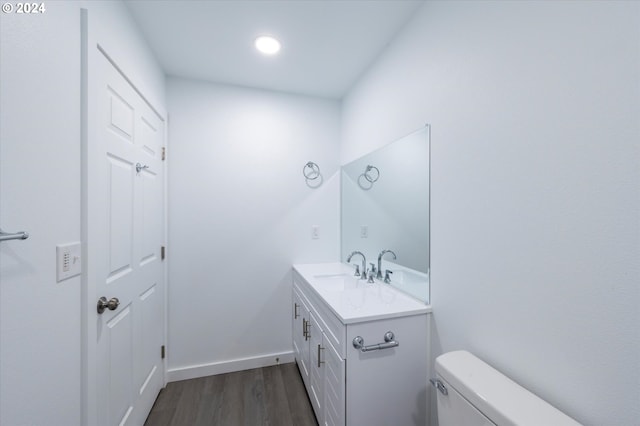 bathroom with hardwood / wood-style floors, vanity, and toilet