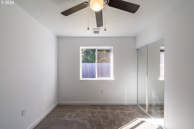 unfurnished bedroom featuring carpet floors, baseboards, a closet, and a ceiling fan