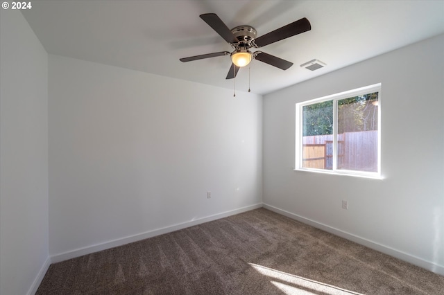 carpeted spare room with ceiling fan and baseboards