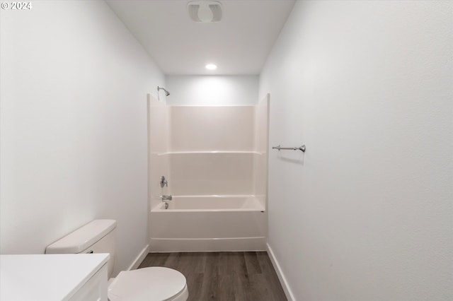 bathroom with wood finished floors, vanity, baseboards, toilet, and shower / bath combination