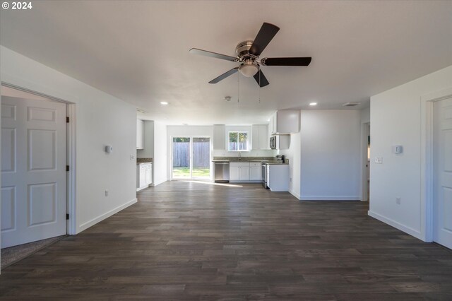 unfurnished living room featuring a ceiling fan, dark wood-type flooring, baseboards, recessed lighting, and a sink
