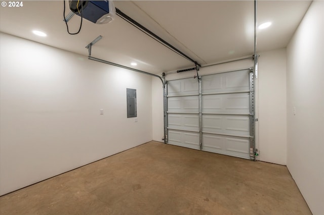 garage featuring a garage door opener, electric panel, and recessed lighting