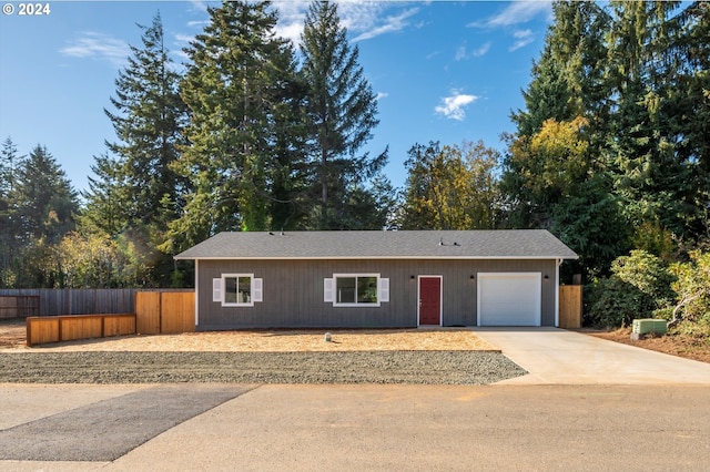 ranch-style house with fence, concrete driveway, and an attached garage