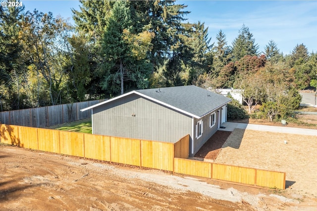 view of property exterior featuring fence and roof with shingles