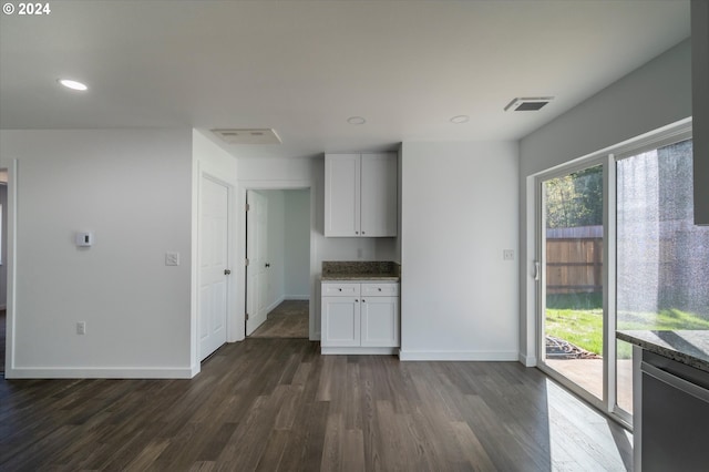 kitchen with dark wood-style flooring, light stone counters, white cabinetry, baseboards, and dishwashing machine
