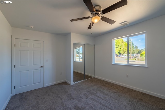 unfurnished bedroom with carpet floors, baseboards, a closet, and a ceiling fan