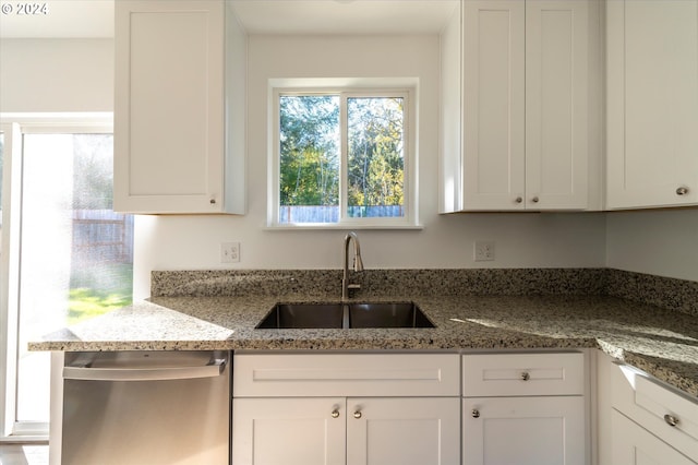 kitchen with white cabinets, dishwasher, stone counters, and sink