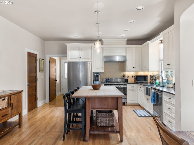 1506 NW Awbrey Rd, Bend, OR 97703 - kitchen featuring appliances with stainless steel finishes, light hardwood / wood-style floors, pendant lighting, and white cabinets