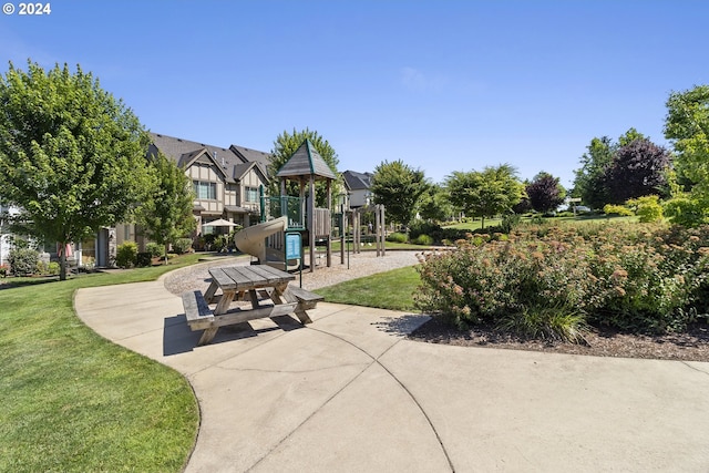 view of home's community featuring a playground and a lawn