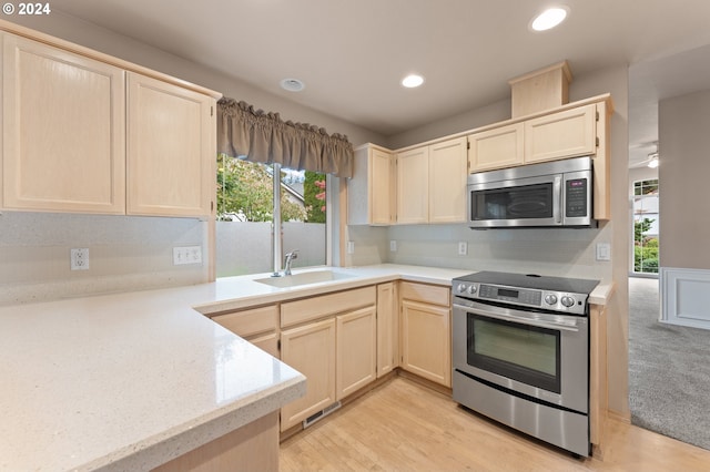 kitchen with light hardwood / wood-style flooring, decorative backsplash, stainless steel appliances, and sink