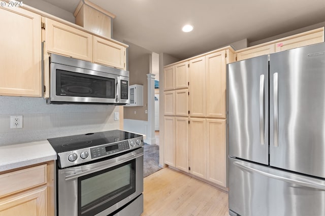 kitchen with light brown cabinetry, appliances with stainless steel finishes, and light wood-type flooring