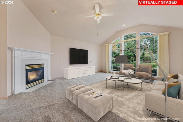 living room with lofted ceiling, light colored carpet, a tile fireplace, and ceiling fan