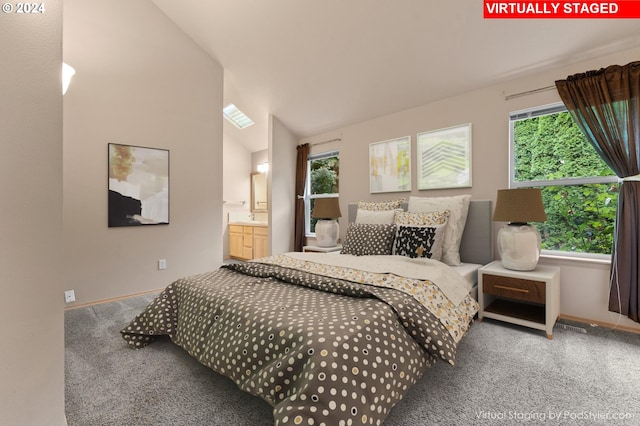 bedroom featuring vaulted ceiling, ensuite bathroom, and carpet flooring