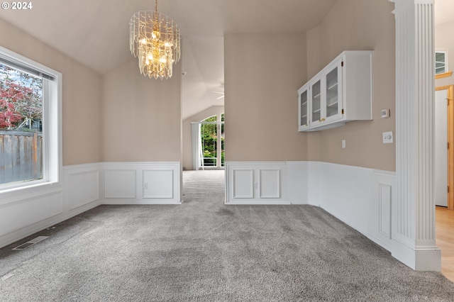 interior space featuring light carpet, lofted ceiling, and an inviting chandelier