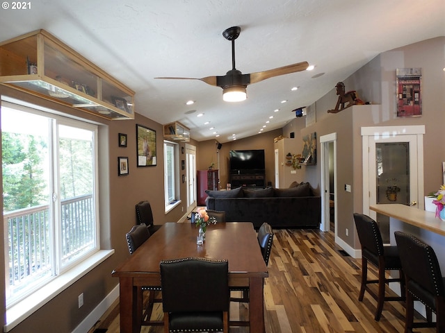 dining space featuring dark wood-type flooring, ceiling fan, and vaulted ceiling