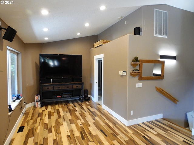 unfurnished living room featuring light wood-type flooring and vaulted ceiling