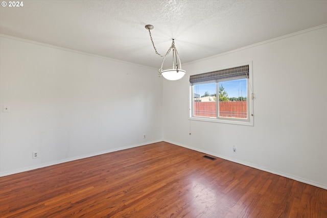 unfurnished room with a textured ceiling, wood-type flooring, and crown molding