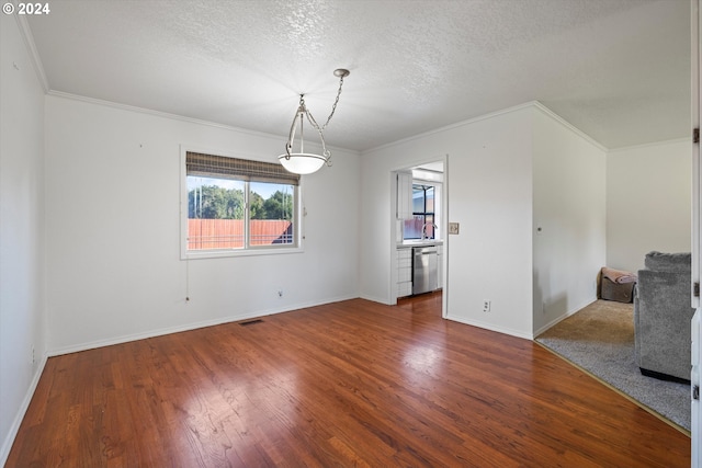 unfurnished dining area featuring wood-type flooring, a textured ceiling, and ornamental molding